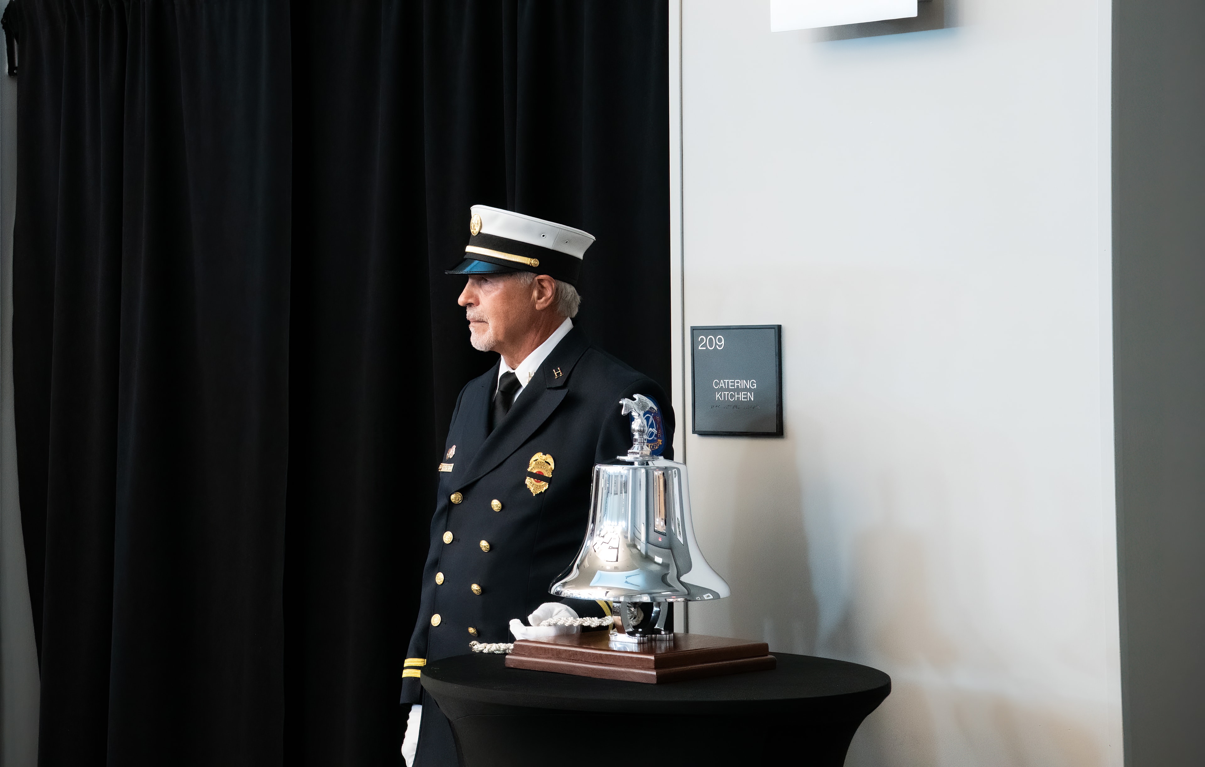 SJFD officer standing at attention beside the ceremonial bell during the 9/11 Remembrance Ceremony