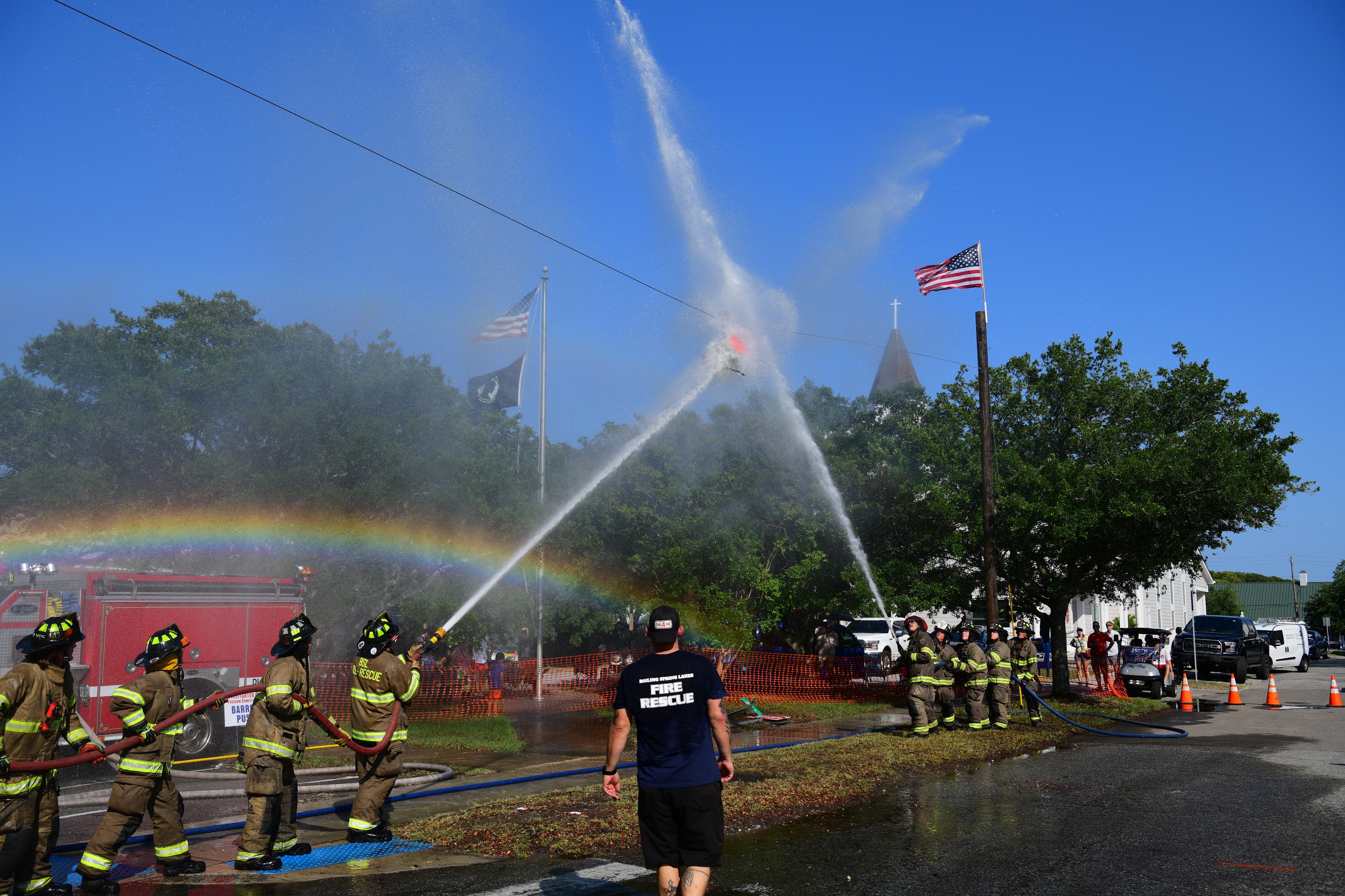 SJFD volunteers creating a rainbow arc with a water spray during the hose challenge