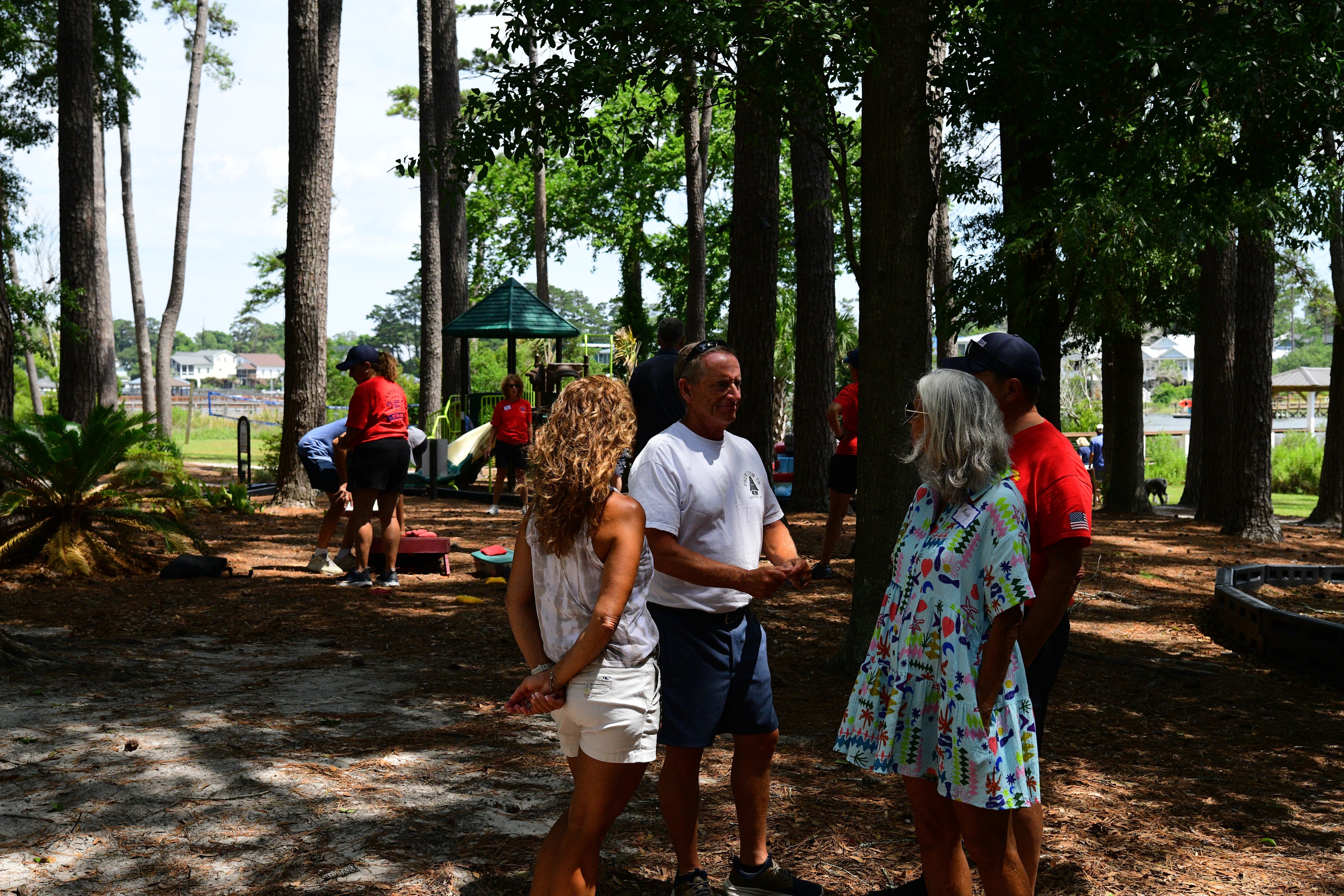 Volunteers and guests mingling in the park near the playground area