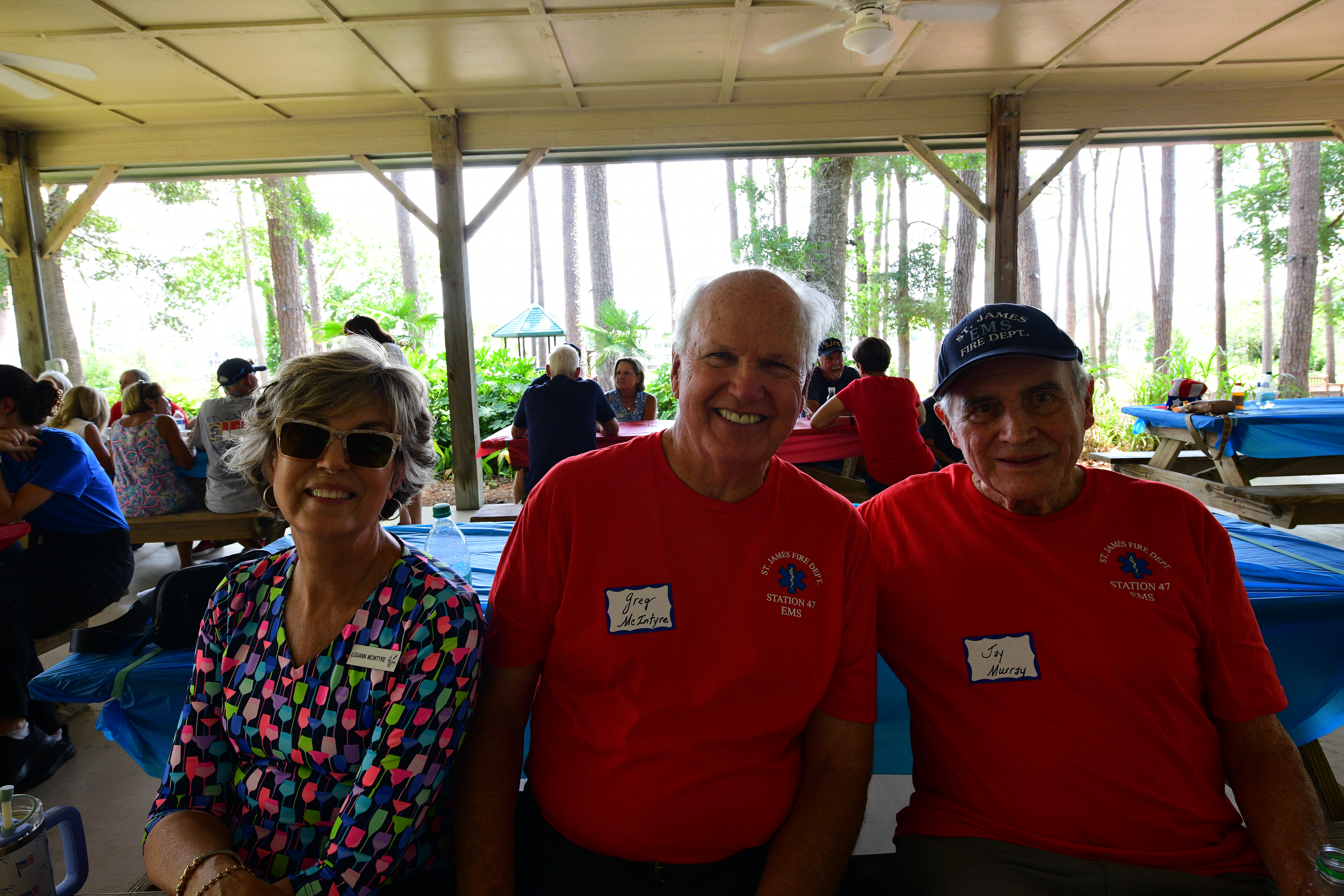 LuAnn McIntyre, Greg McIntyre, and Jay Murray smiling at a table inside the pavilion