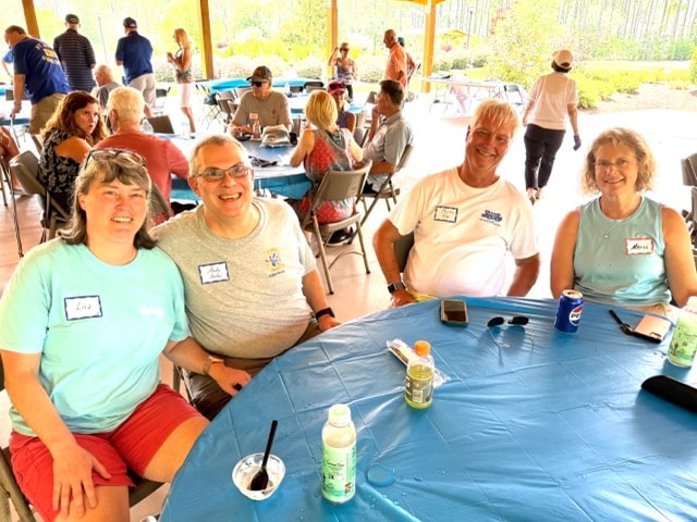 Four SJFD volunteers smile together at a round table at the annual picnic