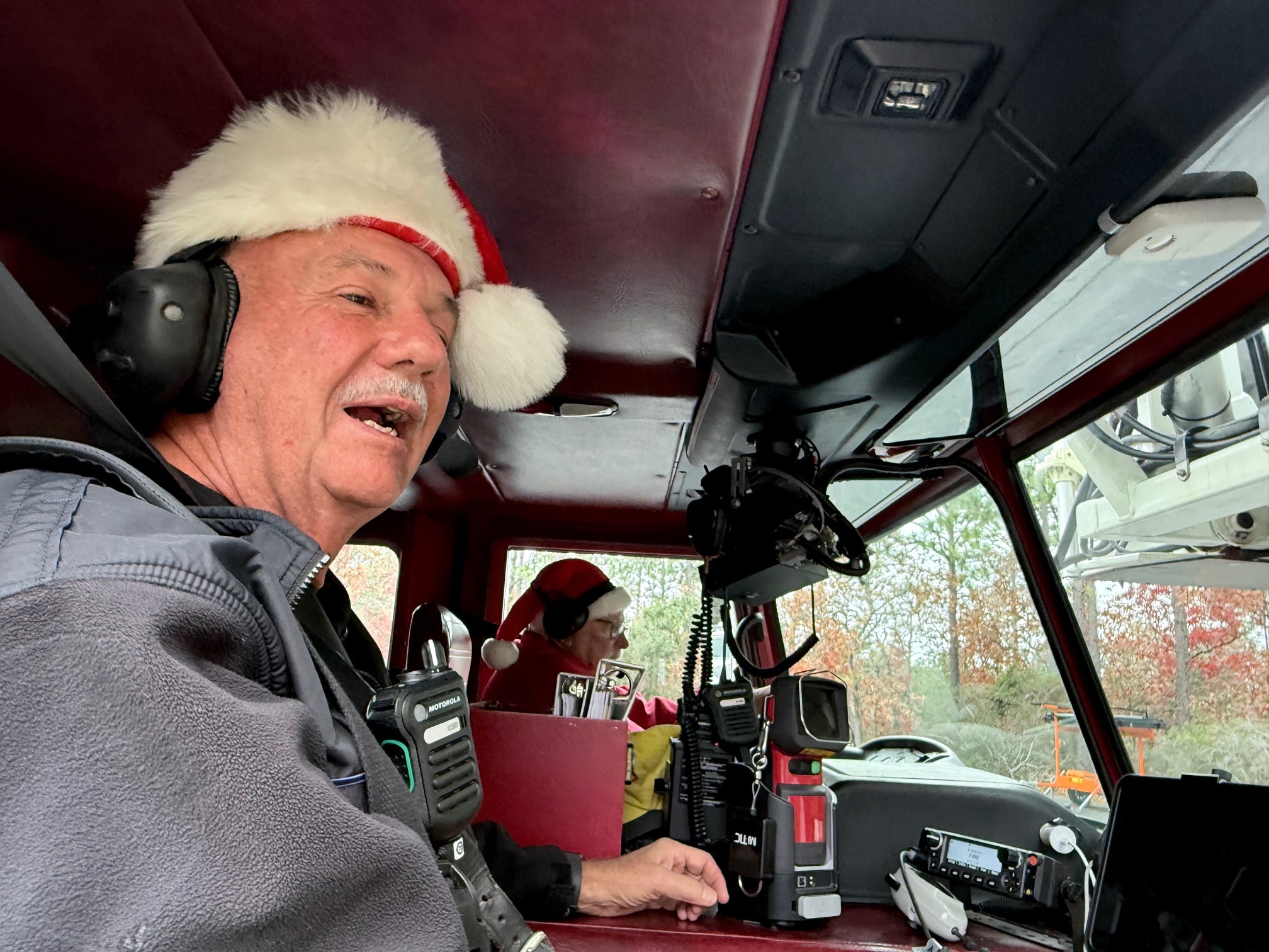 SJFD volunteer in Santa hat at the wheel of the fire truck during the Santa visit